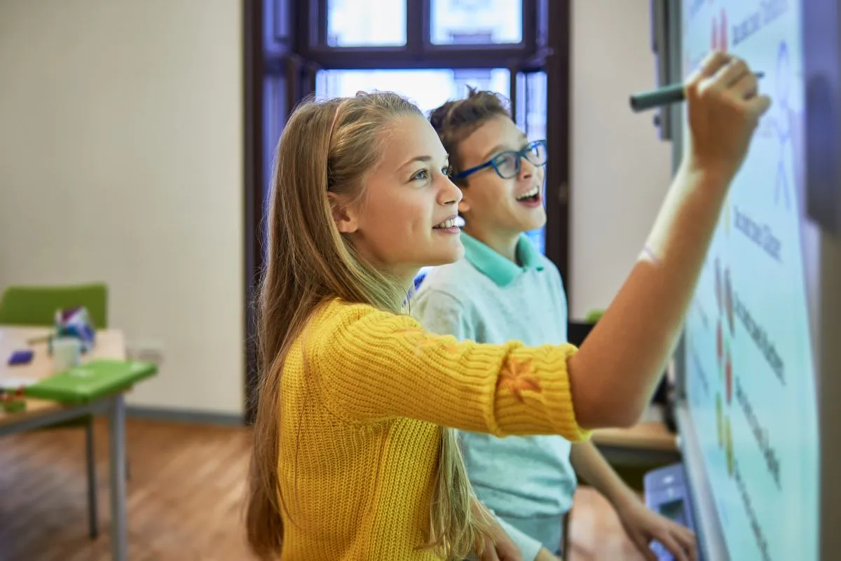 A teacher working with a small group of children at a classroom table