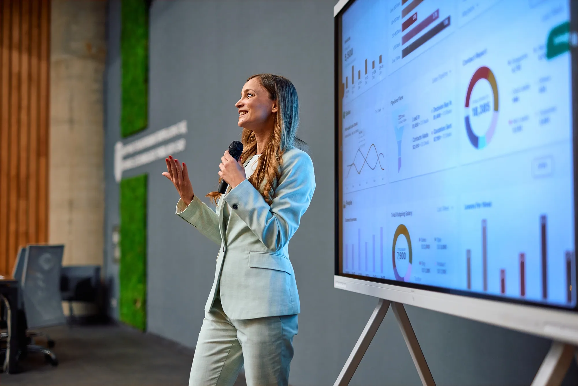 A presenter walking a room through an enrollment report on a large screen